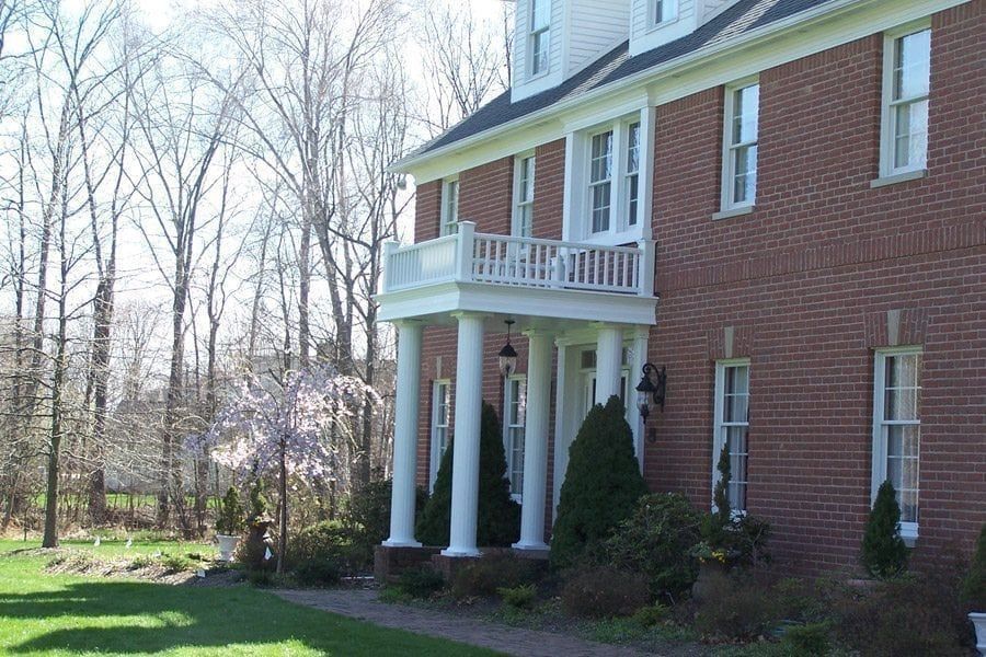 A large brick house with a porch and columns