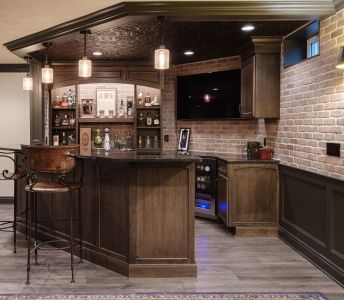 There is a bar in the middle of the room with a brick wall.