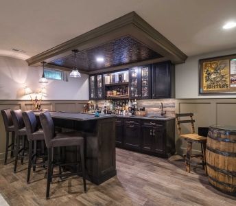 A basement with a bar , chairs , and a barrel.