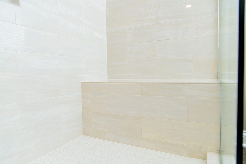 A bathroom with a walk in shower and a glass door.