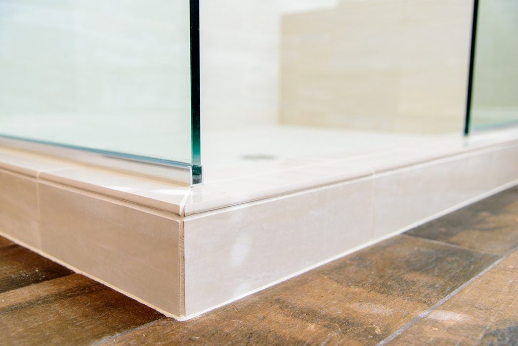 A bathroom with a walk in shower and a tiled floor.