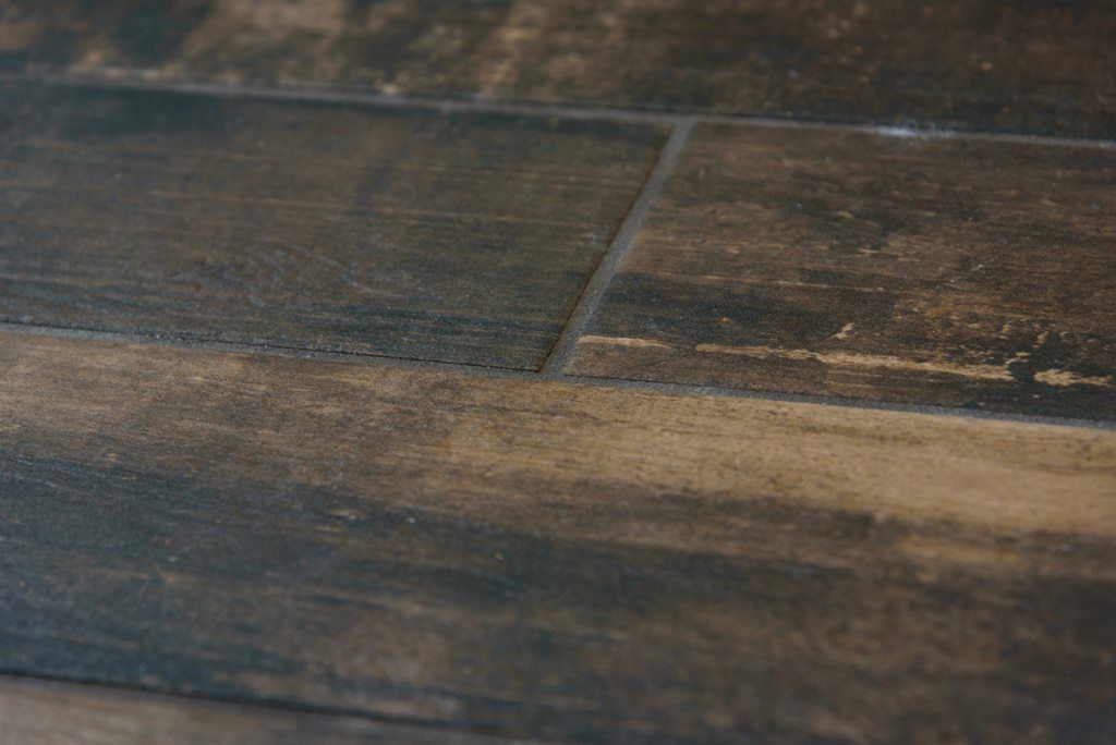 A close up of a tiled floor that looks like wood.