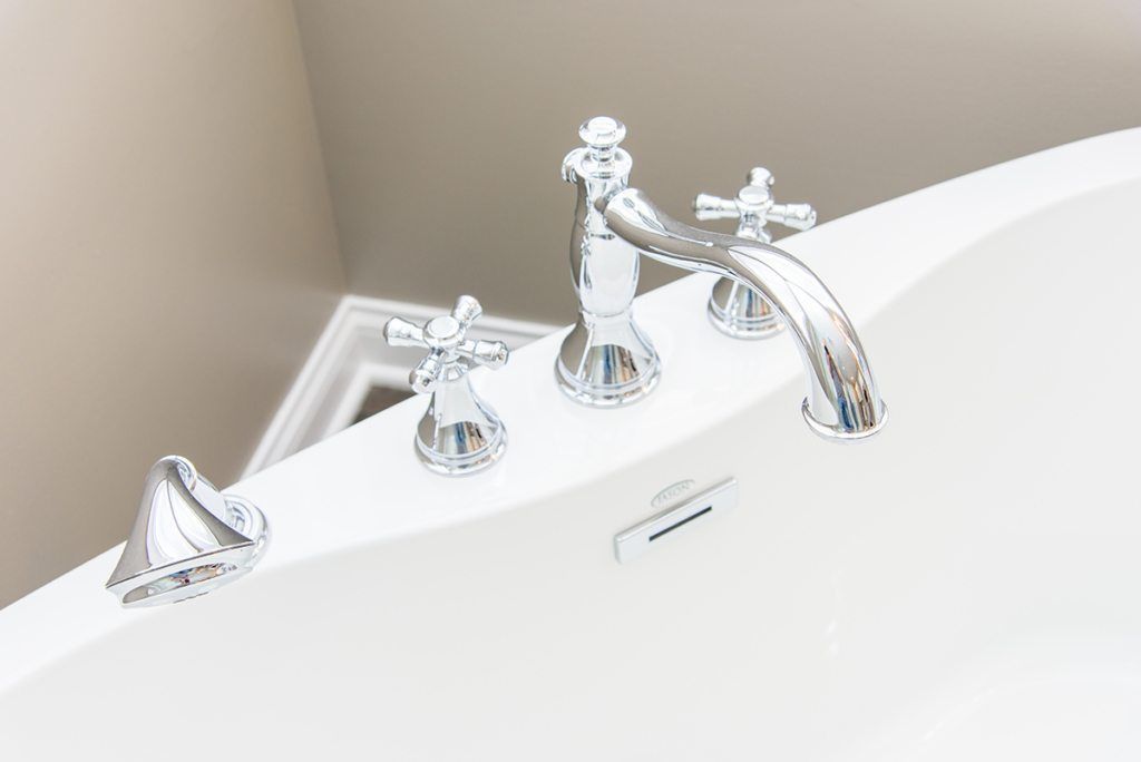 A close up of a bathtub with chrome faucets in a bathroom.