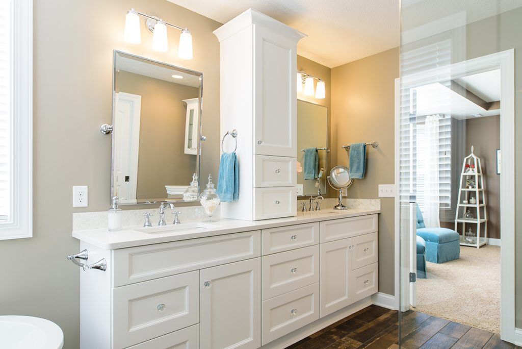 A bathroom with two sinks , a toilet , and a large mirror.