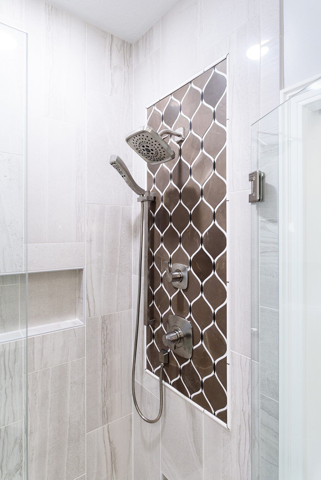 A bathroom with a shower head and a glass door.