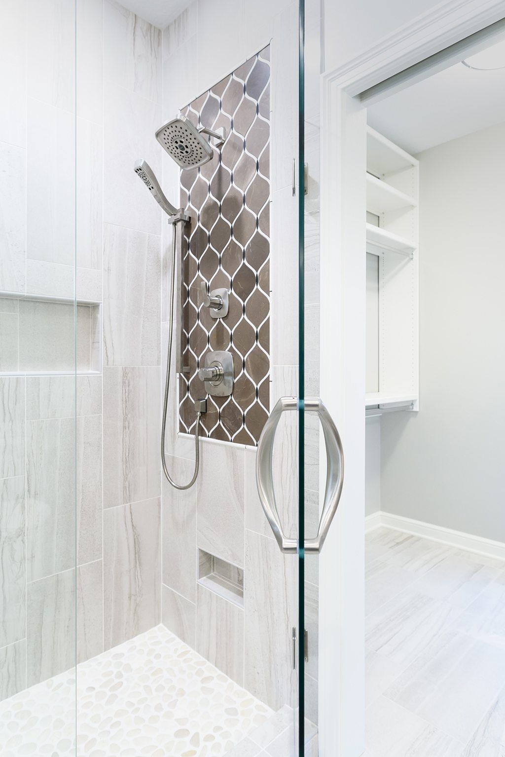 A walk in shower with a glass door and a shower head.