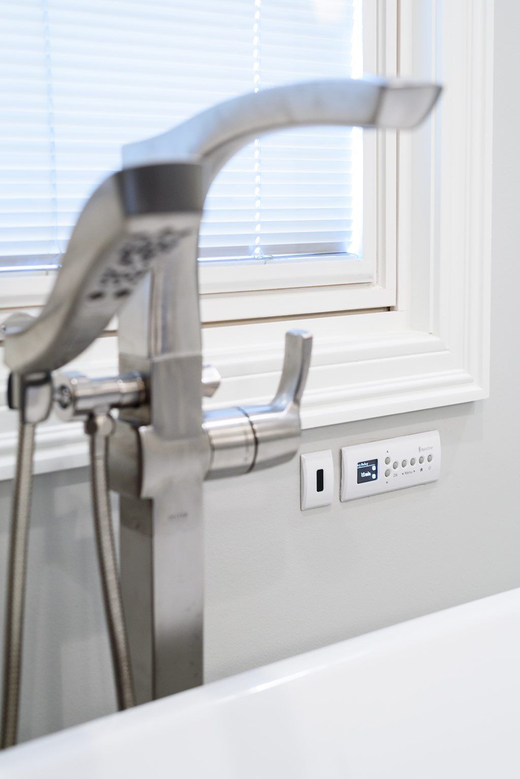 A bathtub with a faucet and a window in the background.