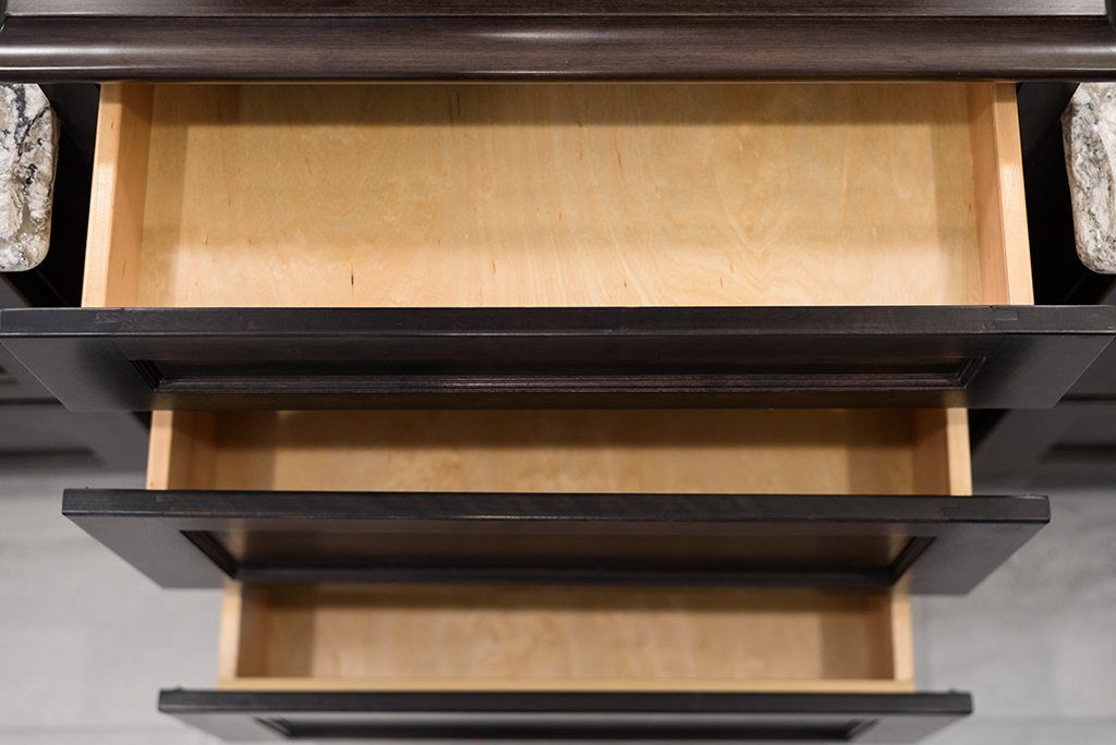 An empty drawer in a kitchen with granite counter tops