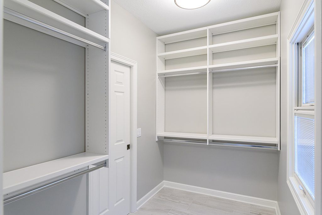 A walk in closet with lots of shelves and a window.
