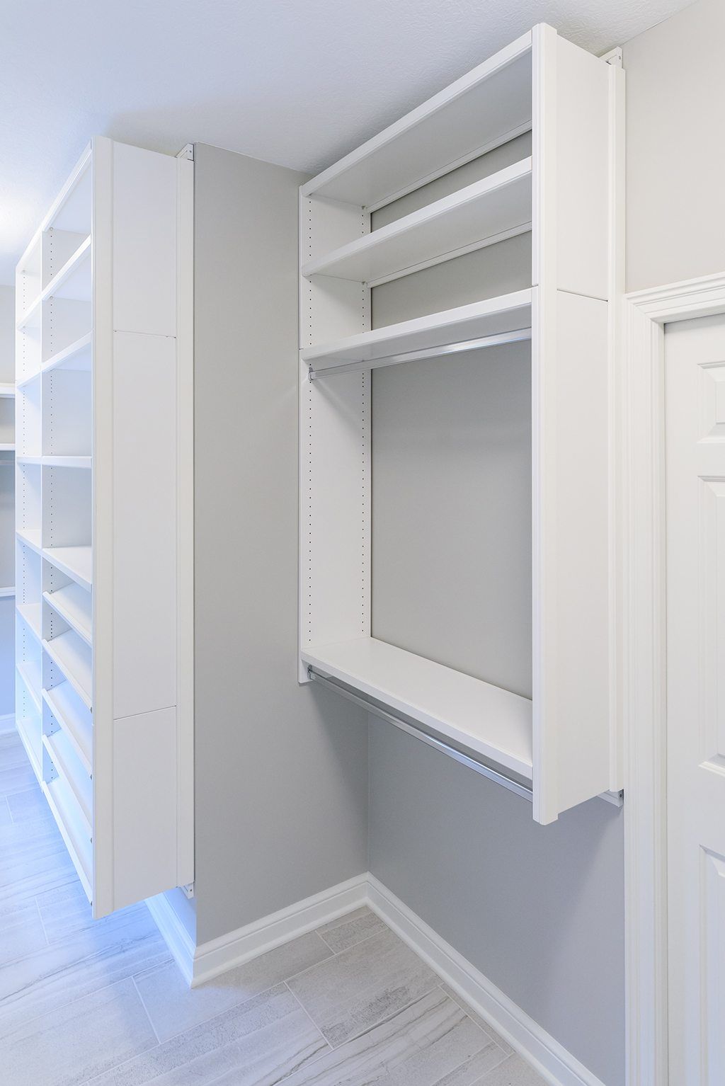 A walk in closet with lots of shelves and a hanging rail.