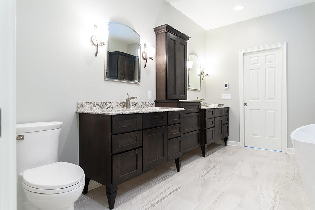 A bathroom with two sinks , a toilet , and a mirror.