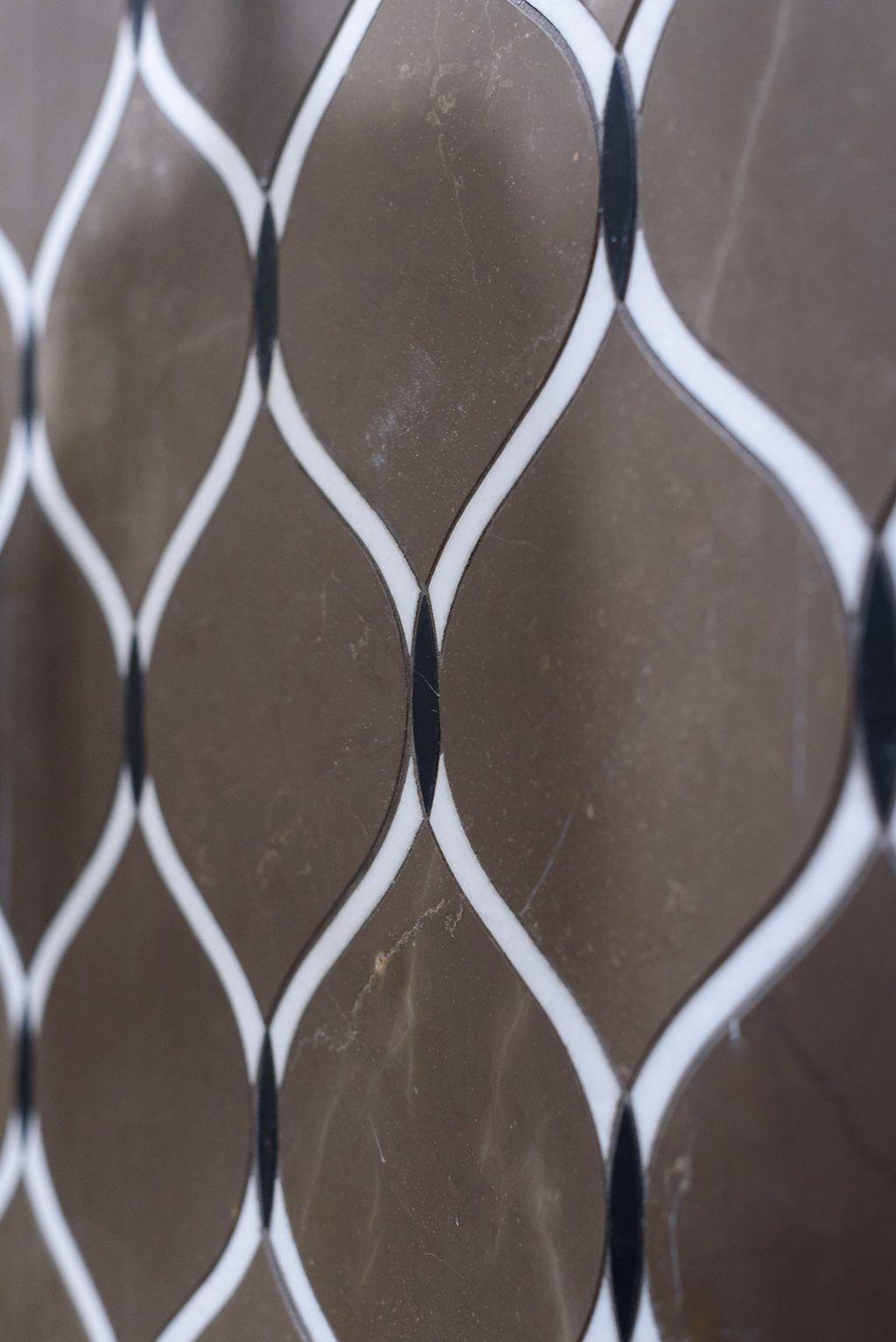 A close up of a chain link fence with a brown background