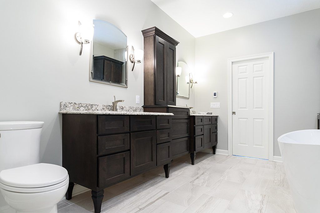 A bathroom with two sinks , a toilet , and a bathtub.