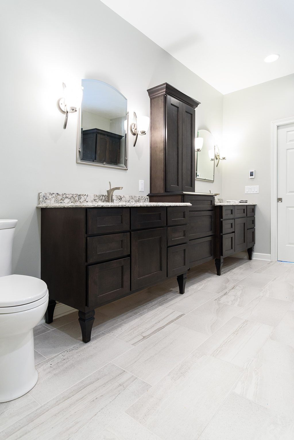 A bathroom with two sinks , a toilet , and a mirror.