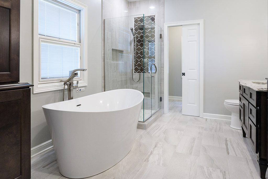 A bathroom with a tub , sink , toilet and shower.
