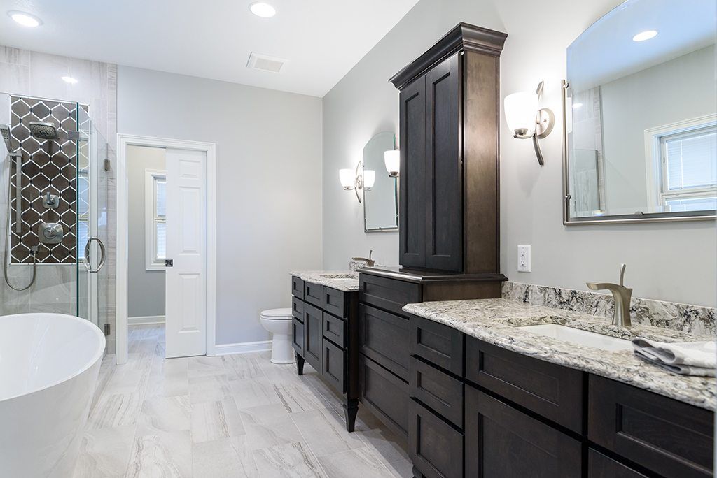 A bathroom with two sinks , a toilet , and a bathtub.