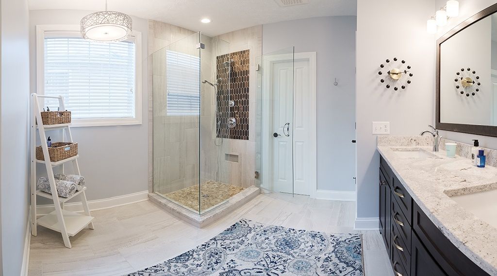 A bathroom with a walk in shower and two sinks.
