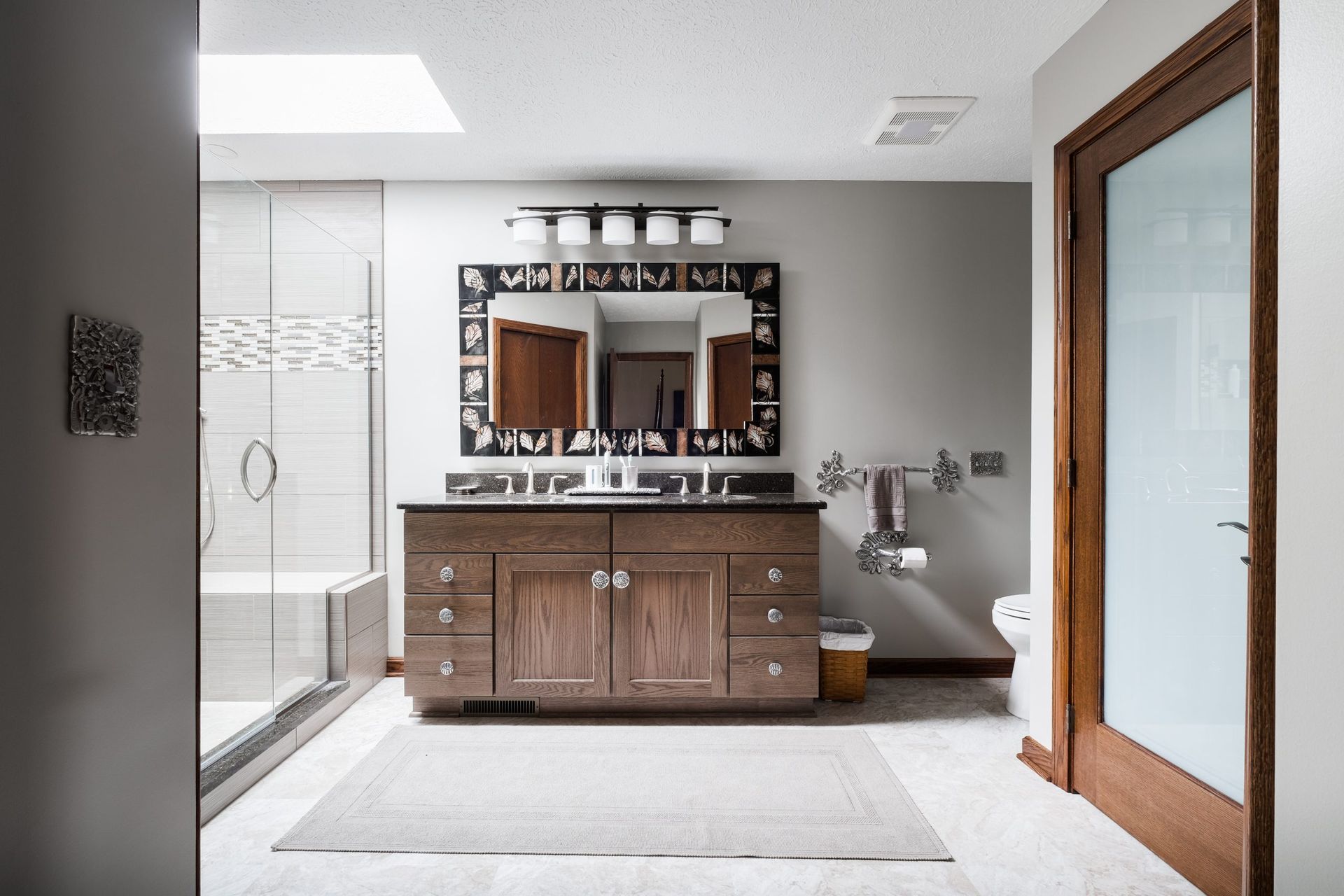 A bathroom with two sinks , a toilet , and a large mirror.