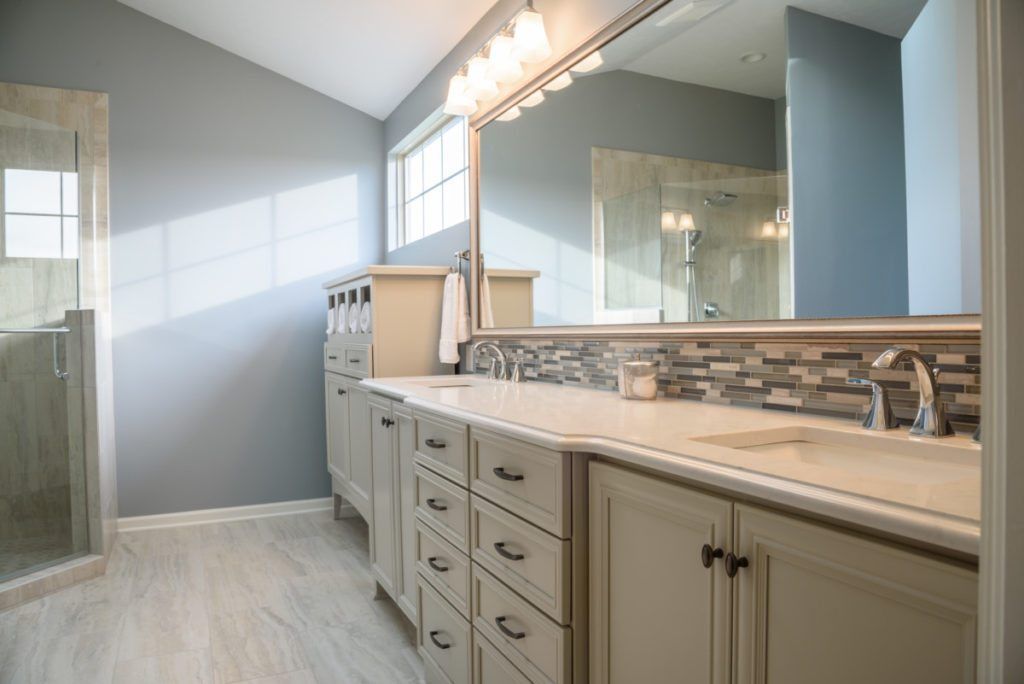 A bathroom with two sinks and a large mirror.