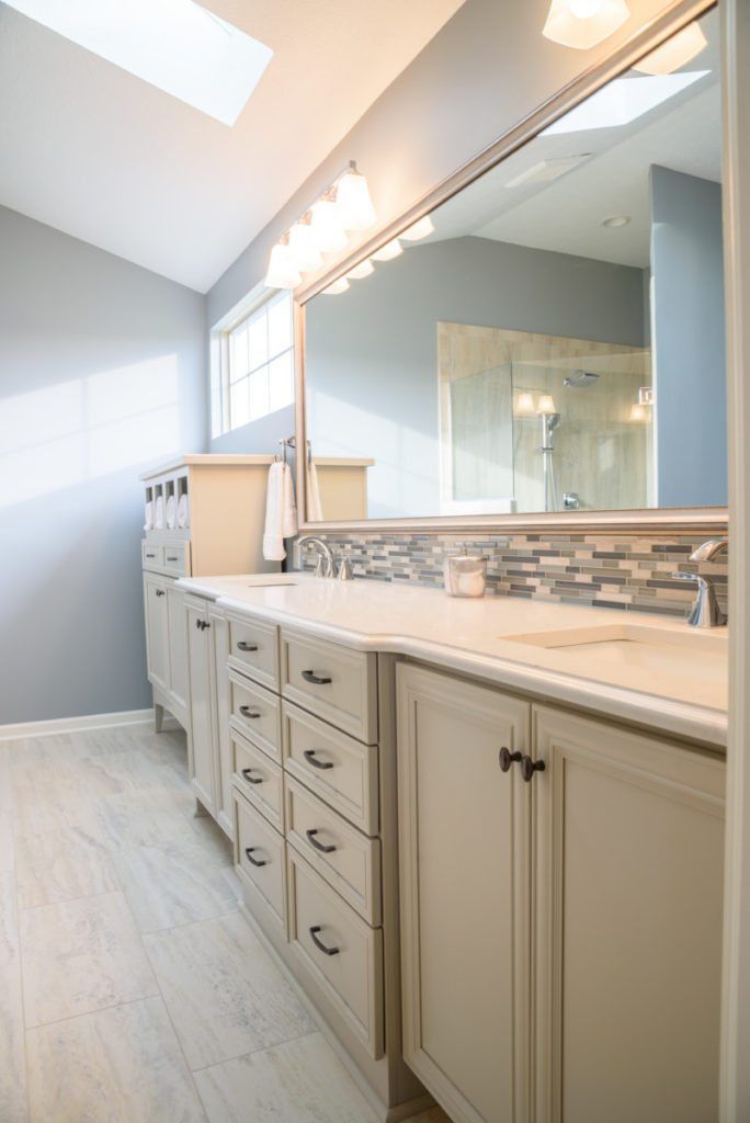 A bathroom with two sinks and a large mirror.