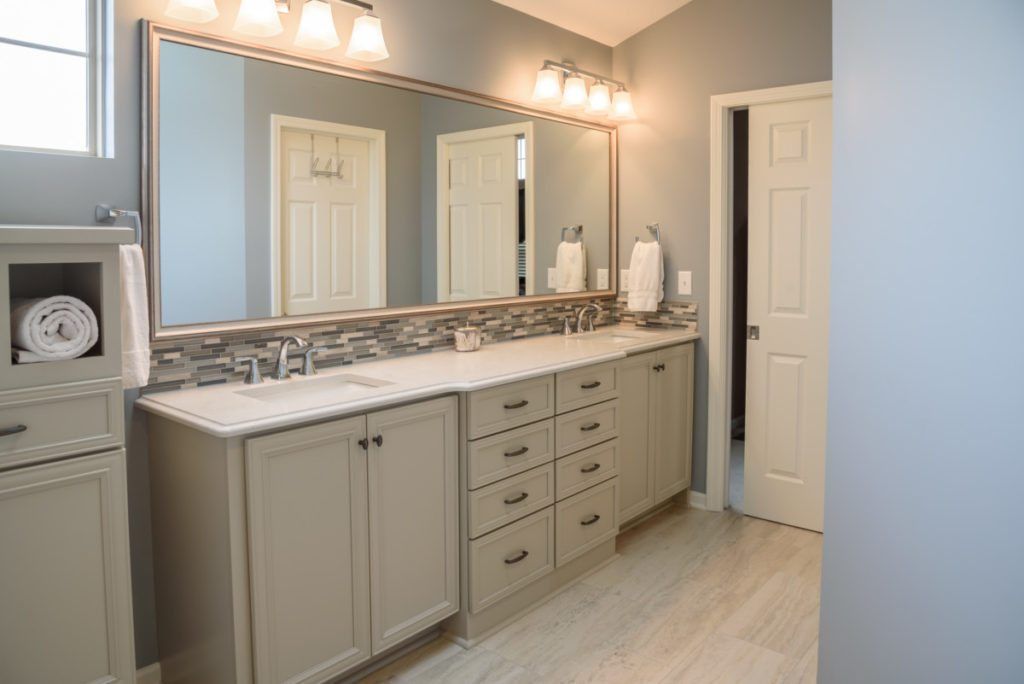 A bathroom with two sinks and a large mirror.
