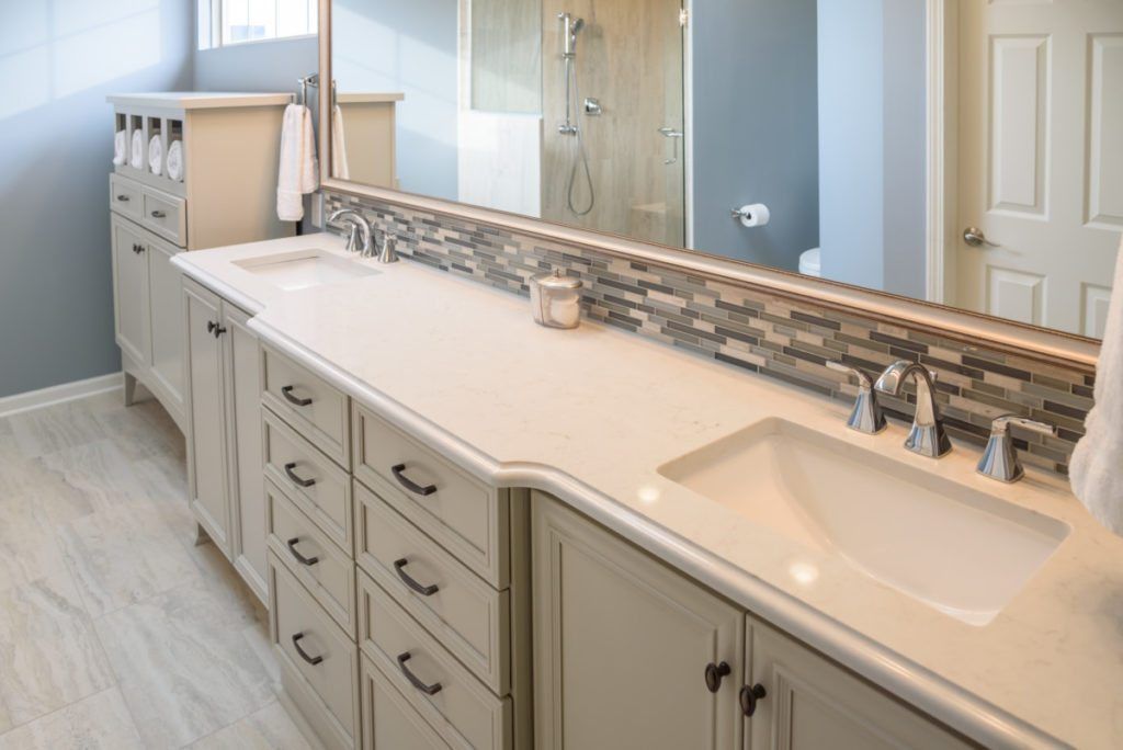 A bathroom with two sinks and a large mirror.