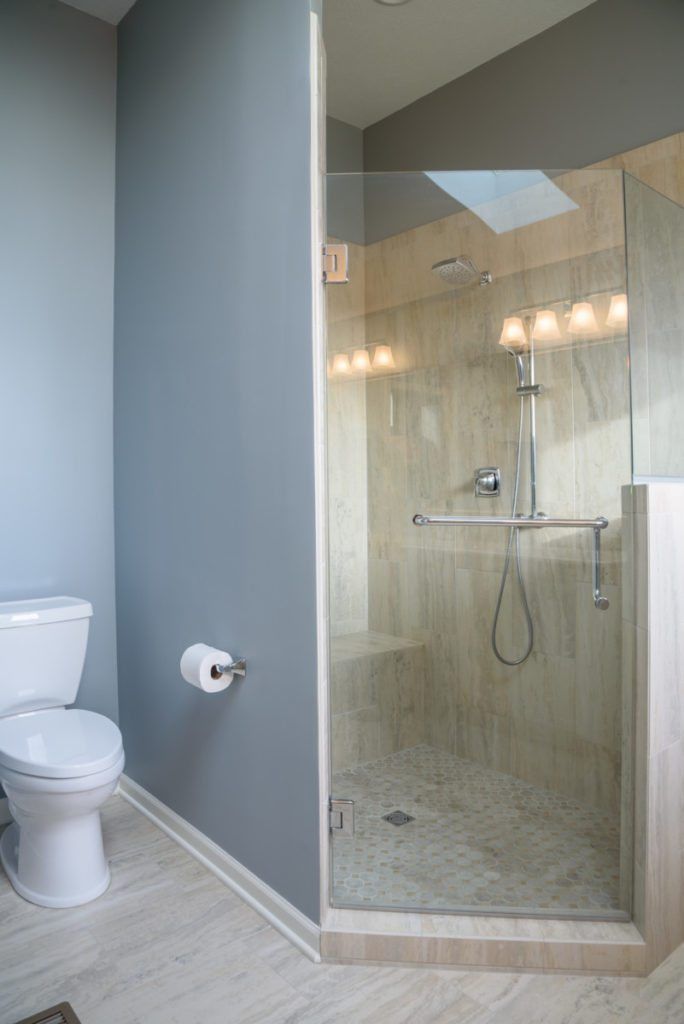 A bathroom with a toilet and a walk in shower.