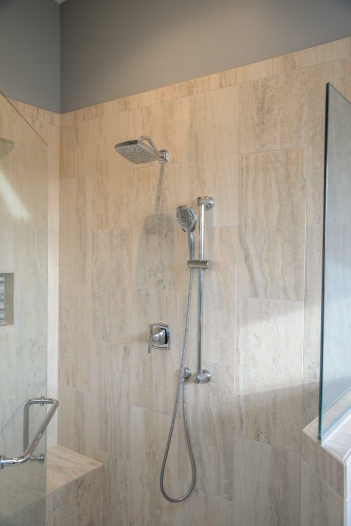 A bathroom with a shower head and a glass door.