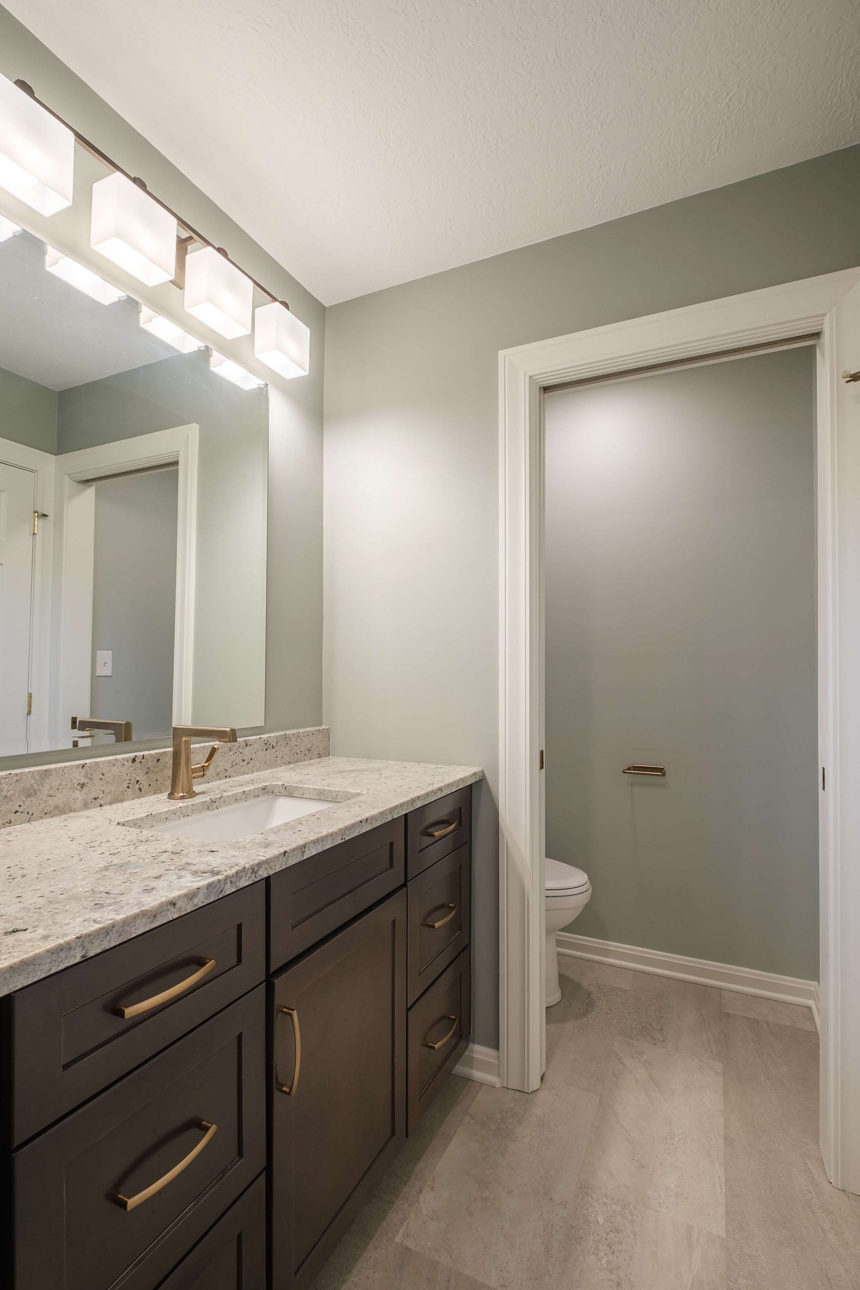 A bathroom with a sink , mirror and toilet.