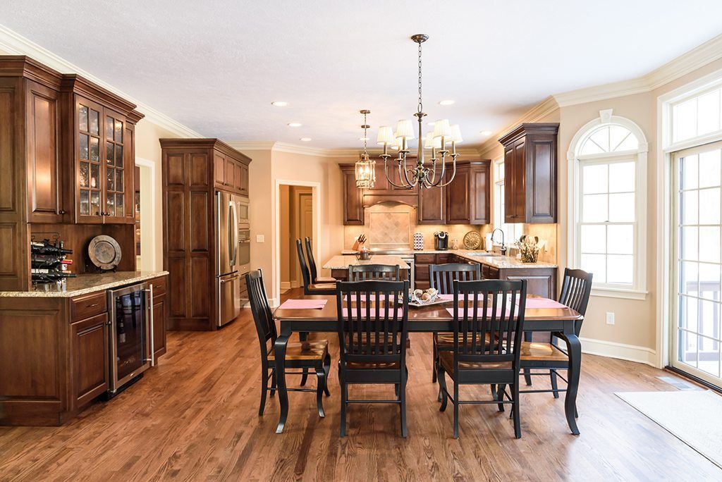 A large kitchen with a dining table and chairs in it.