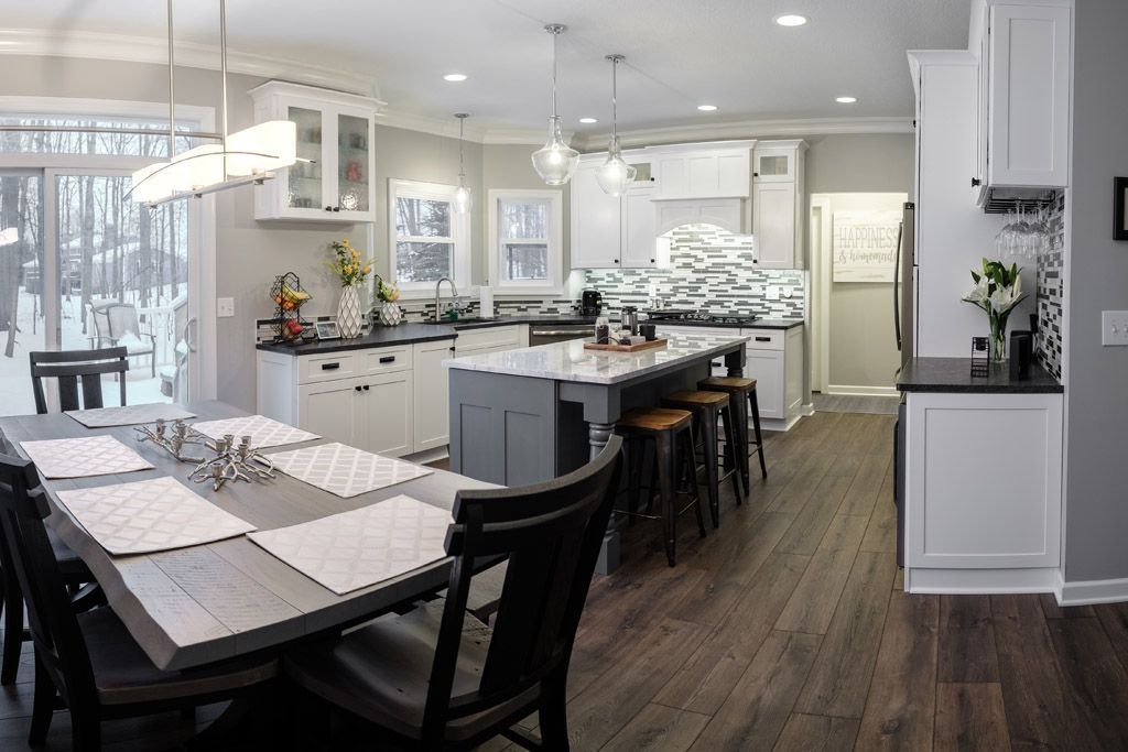 A kitchen and dining room with a large table and chairs.