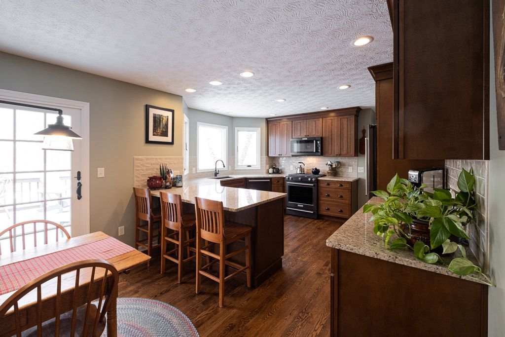 A kitchen with a table and chairs and a large island.