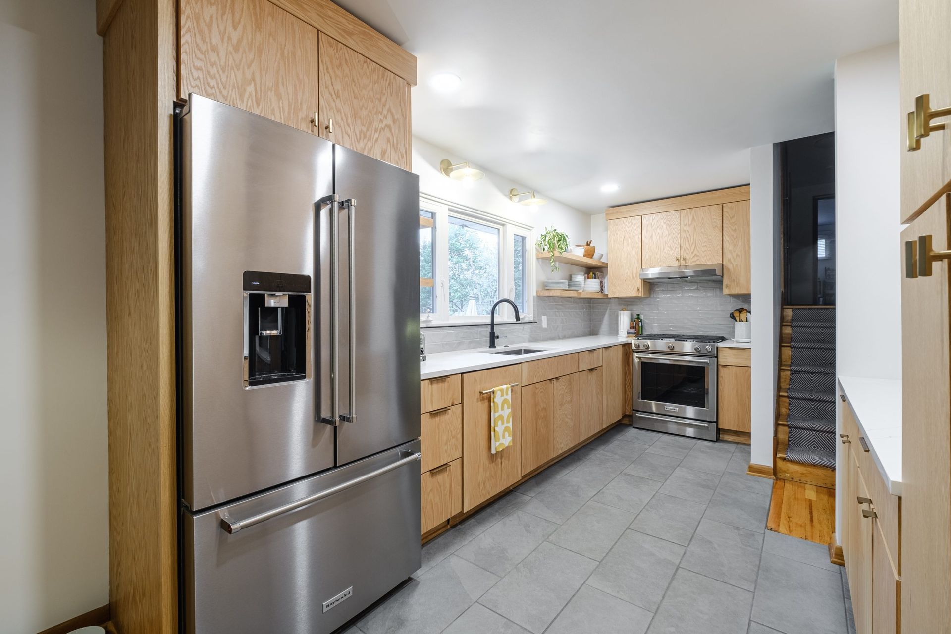 A kitchen with stainless steel appliances and wooden cabinets.