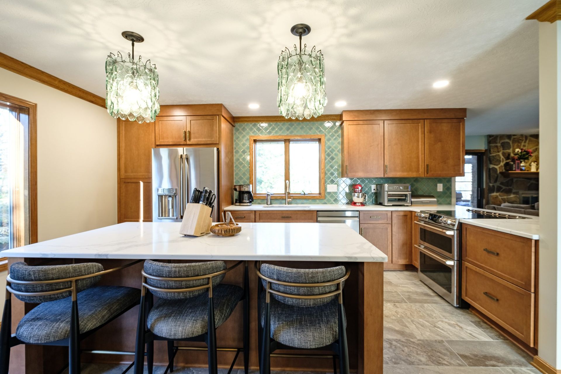 A kitchen with wooden cabinets , stainless steel appliances , and a large island.