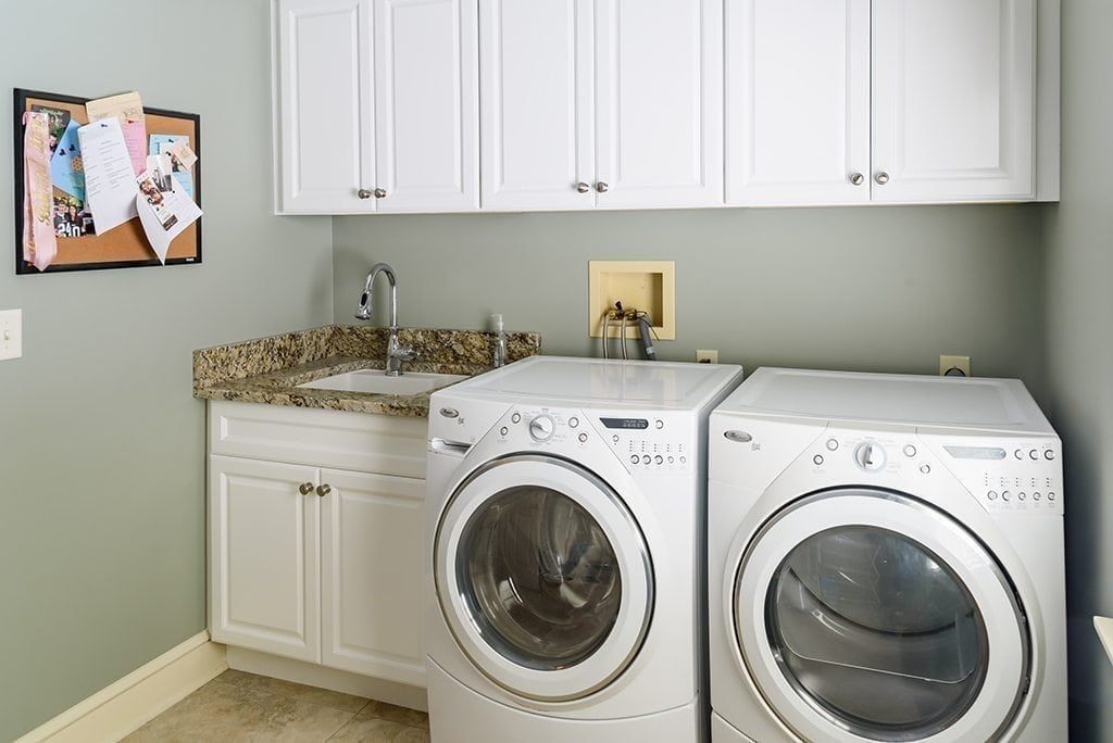 A laundry room with a washer and dryer and a sink.