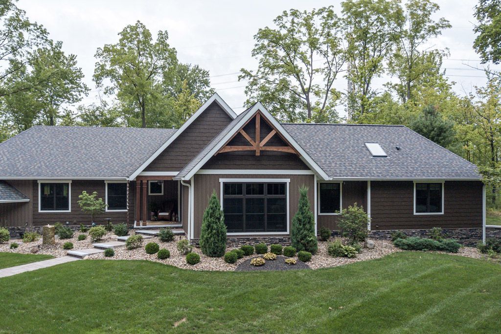 A large brown house with a gray roof and a lot of windows