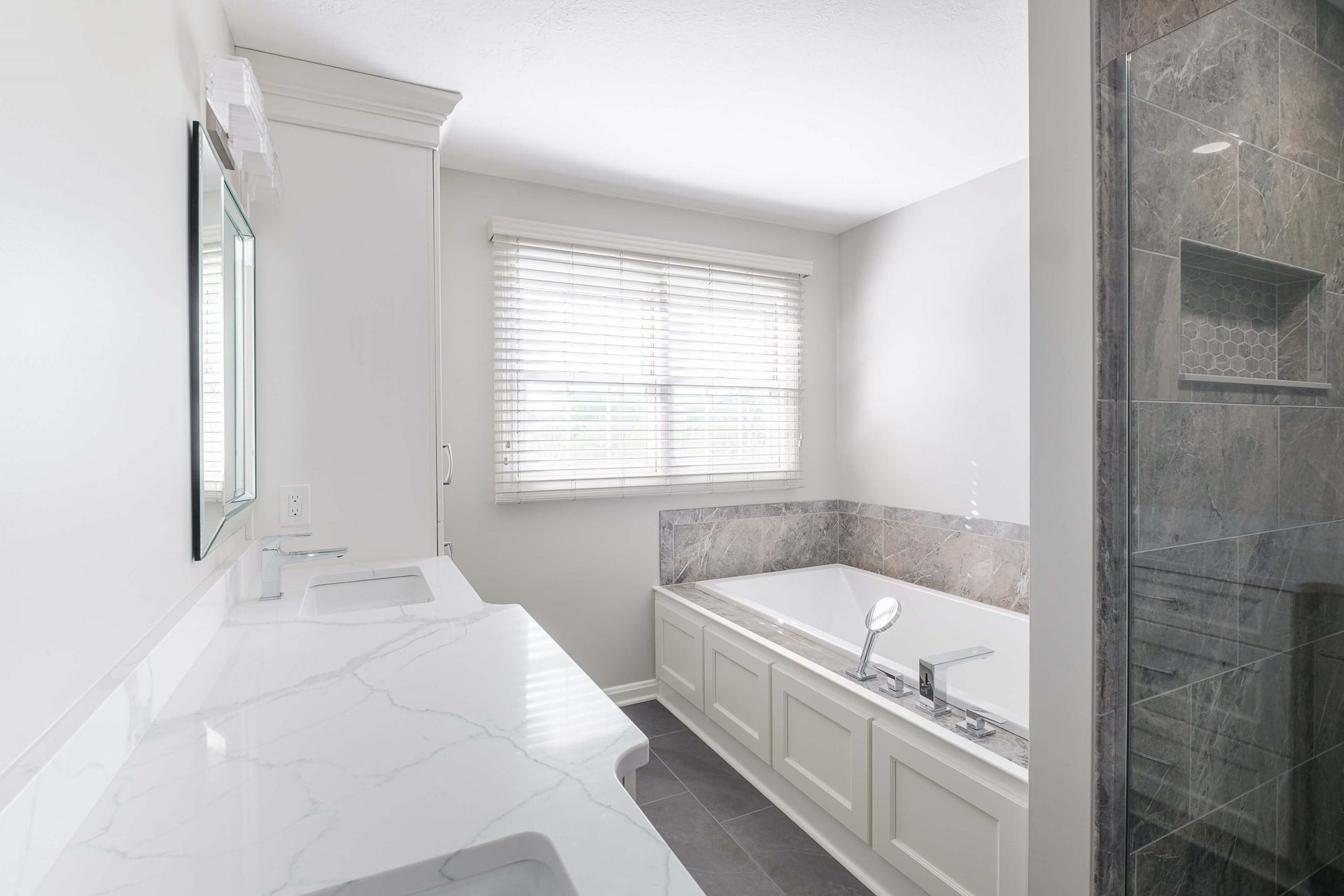 A bathroom with a tub , sink , mirror and walk in shower.