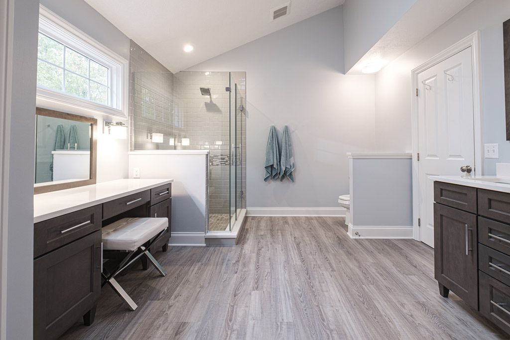 A bathroom with a walk in shower and a vanity.