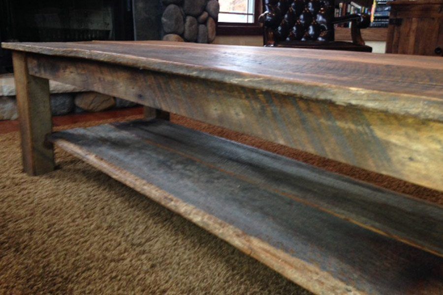 A wooden table with a shelf underneath it in a living room