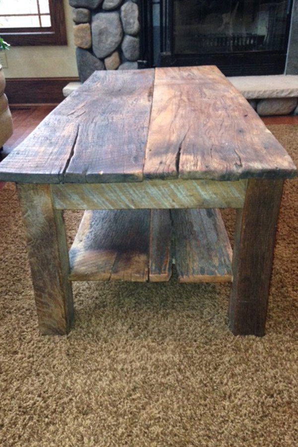A wooden table is sitting on a carpet in a living room next to a fireplace.