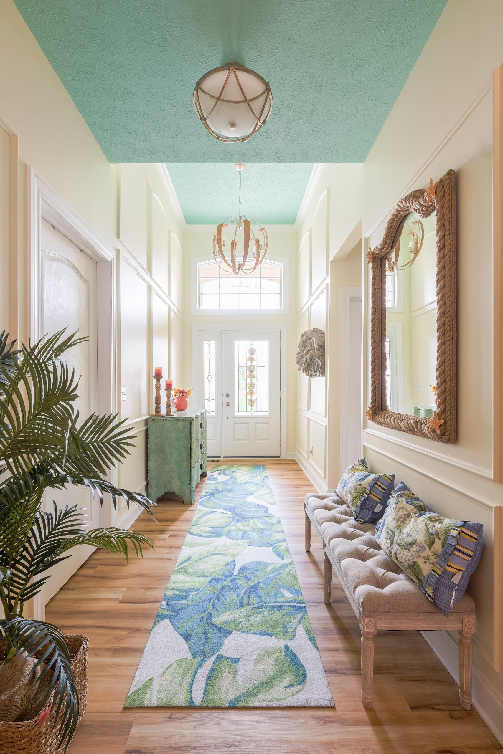 A long hallway with a blue ceiling and a rug.