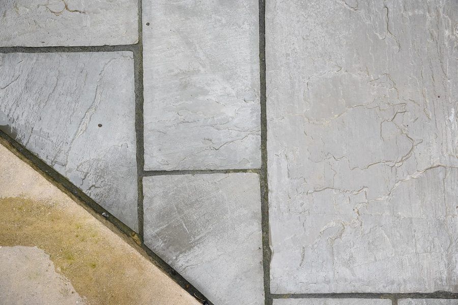 A close up of a tiled floor with a staircase in the background.