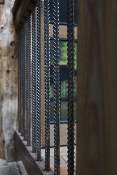 A close up of a metal railing with a building in the background