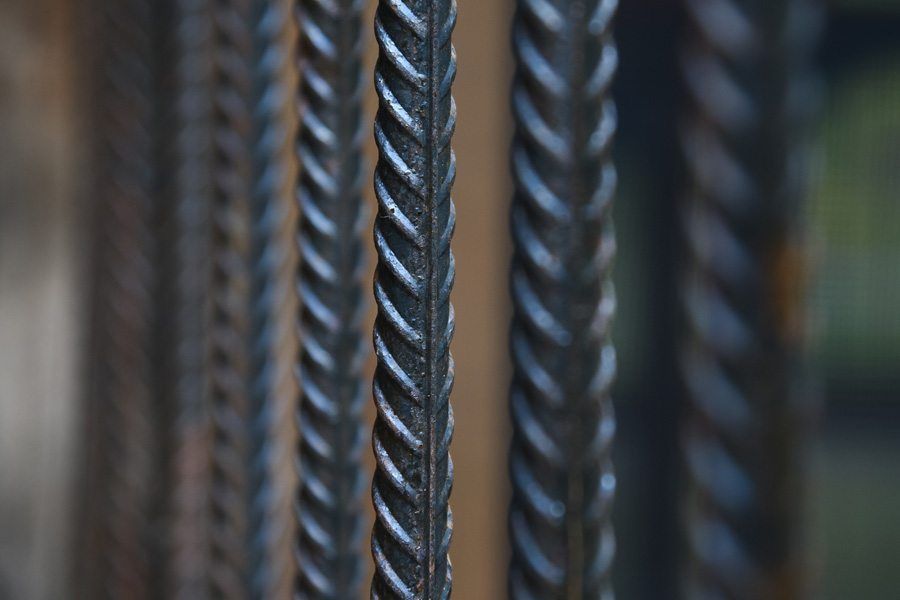 A close up of a bunch of metal bars hanging from a fence.