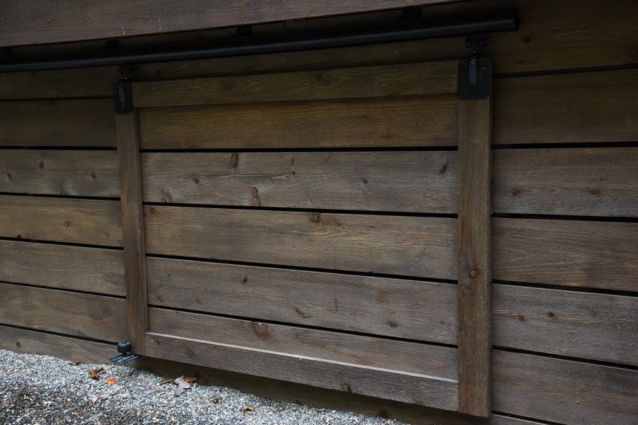 A close up of a wooden fence with a sliding door.