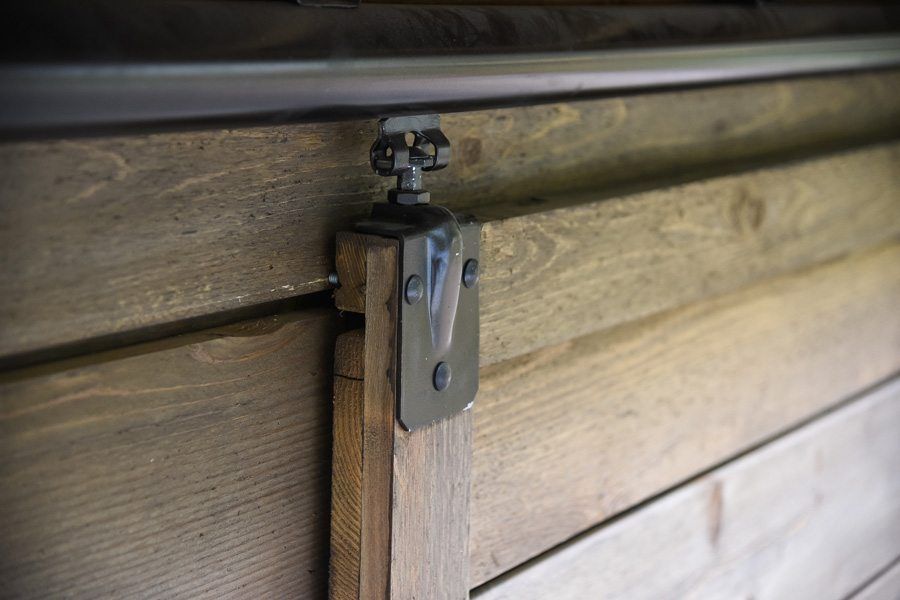 A close up of a sliding barn door on a wooden wall.