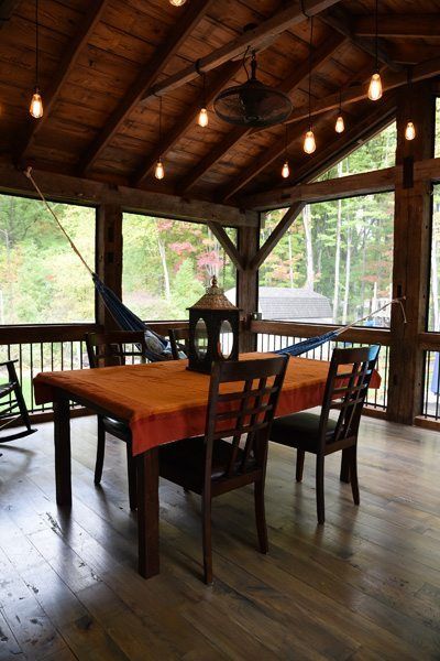 A screened in porch with a table and chairs