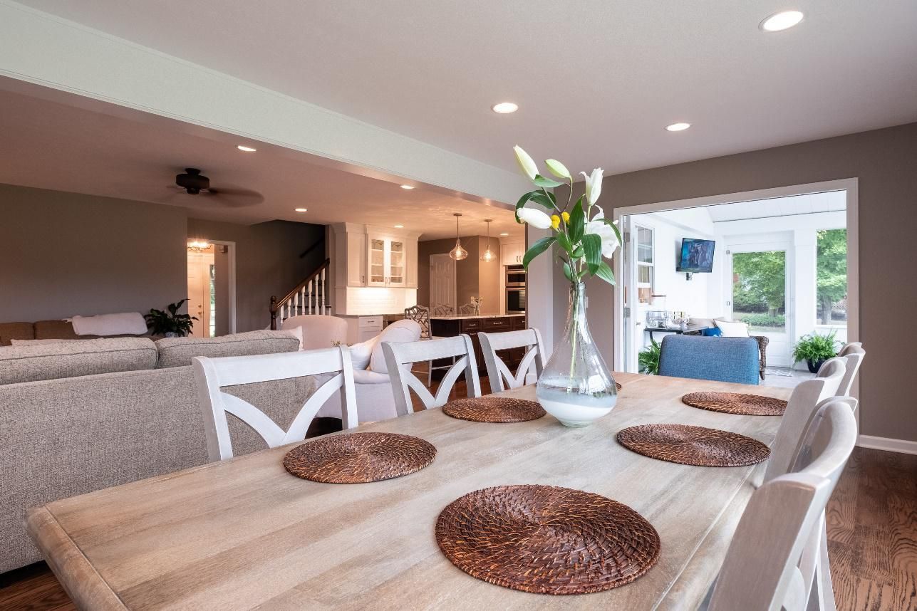 A dining room table with a vase of flowers on it.