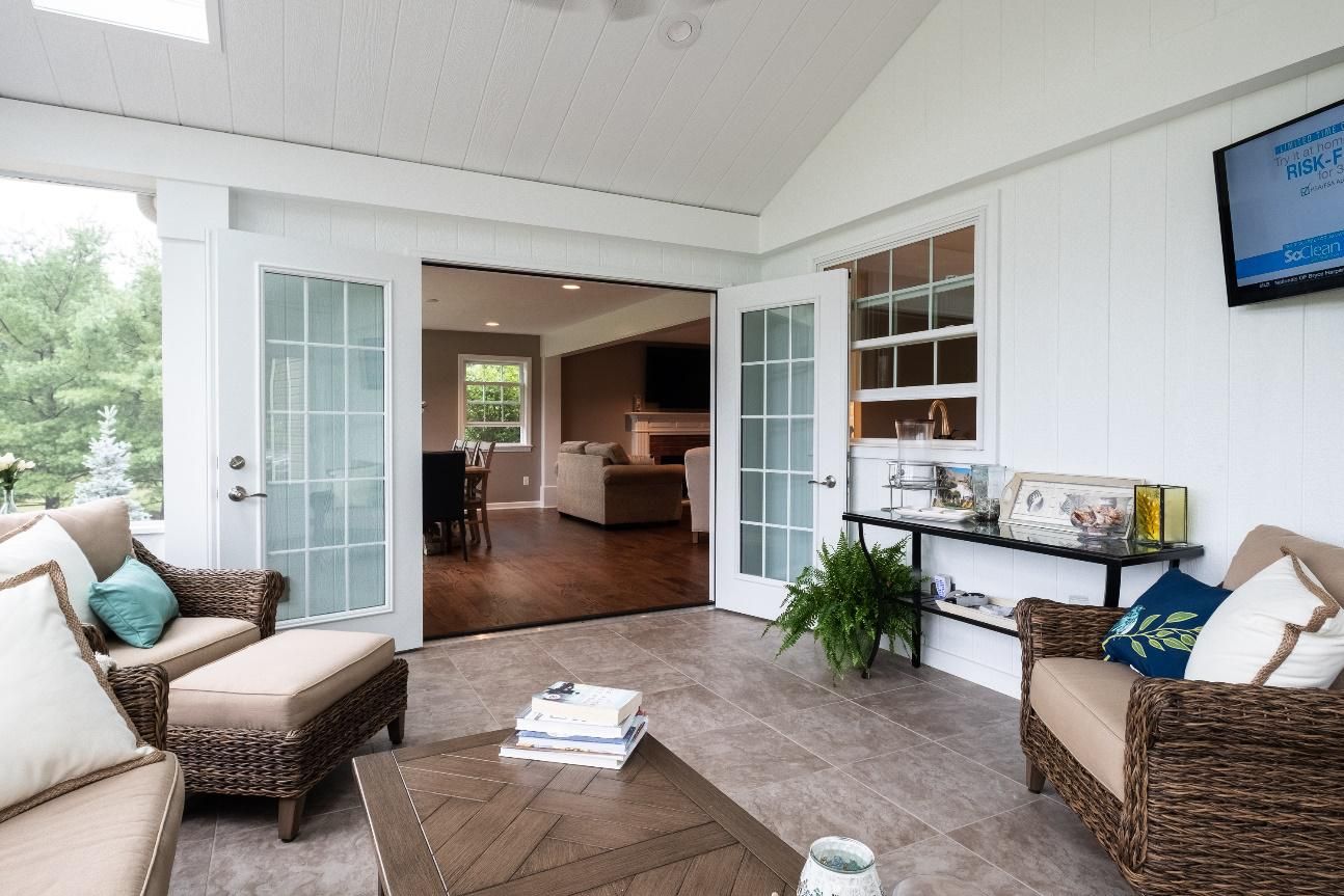 A living room with wicker furniture and a flat screen tv