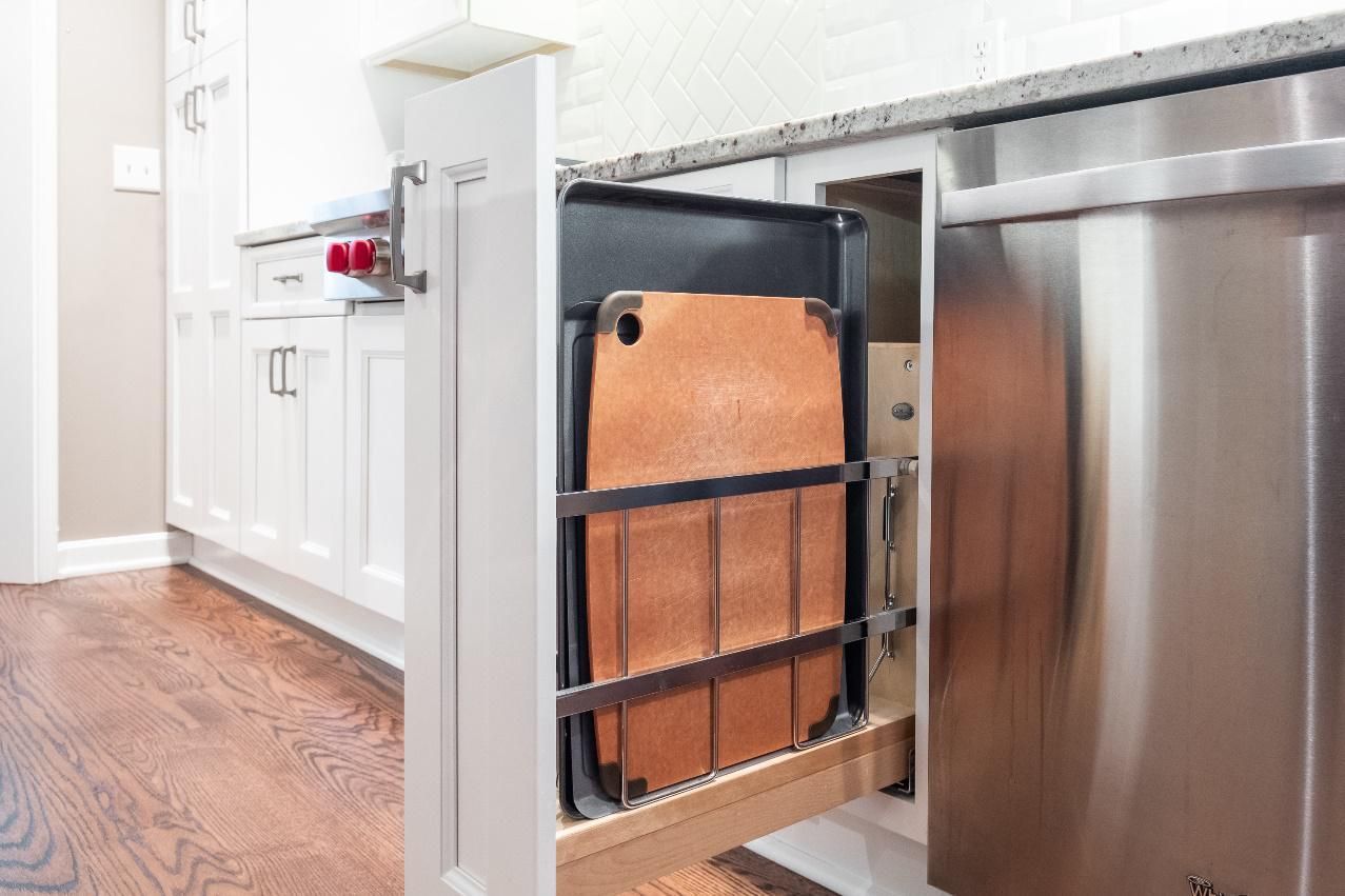 A cutting board is sitting in a pull out drawer in a kitchen.
